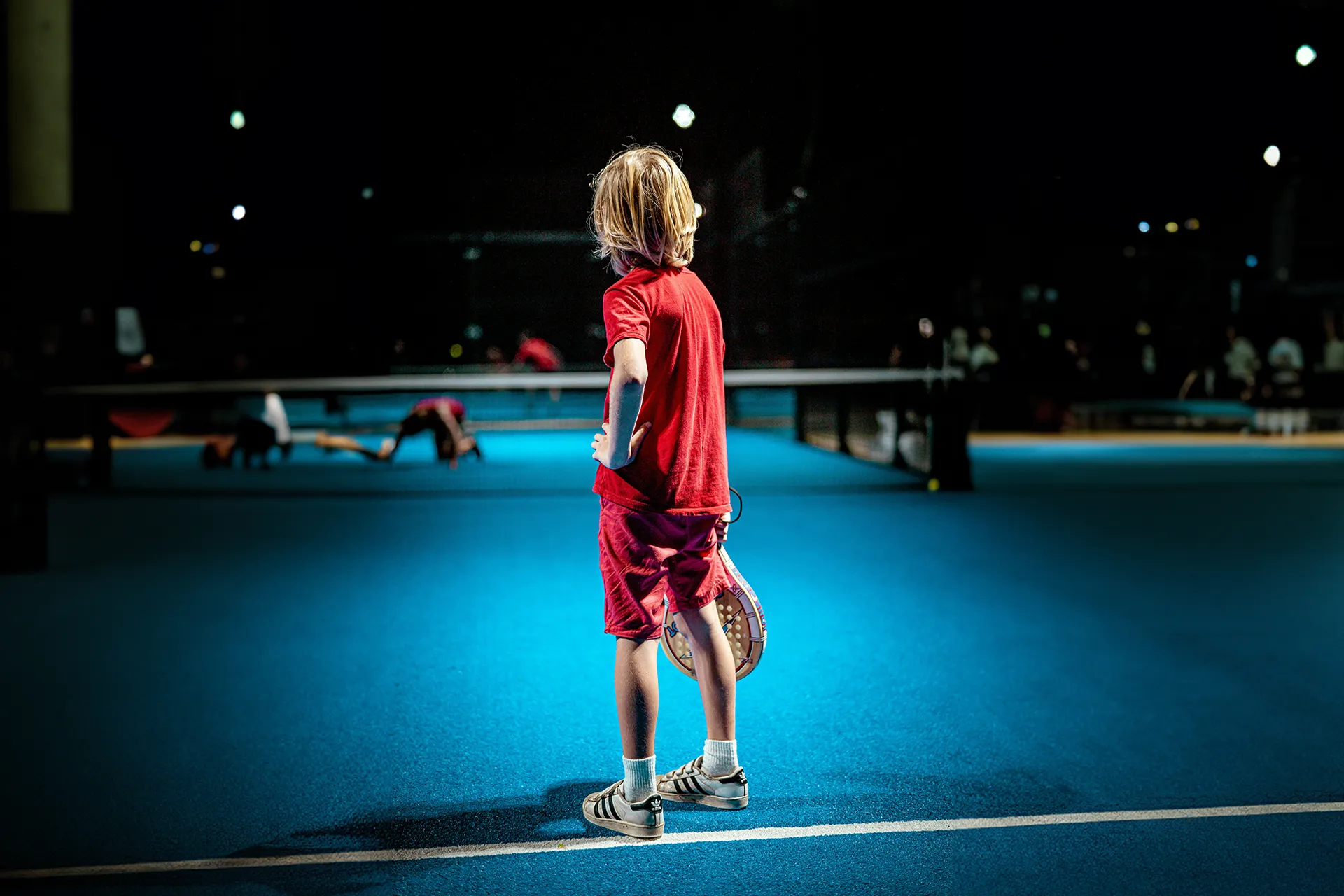 niño en una pista de tenis
