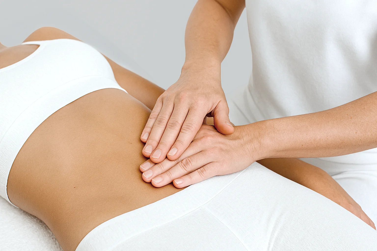 osteopata poniendo las manos en el estomago de una paciente